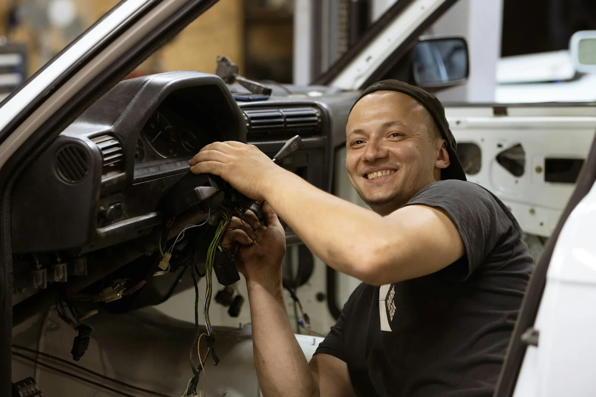 Smiling technician working on a vehicle interior