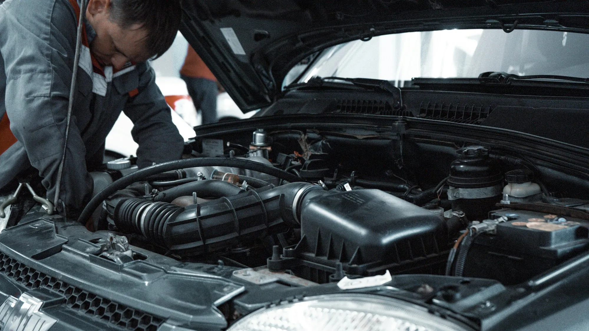 Two technicians looking into the engine bay of a car